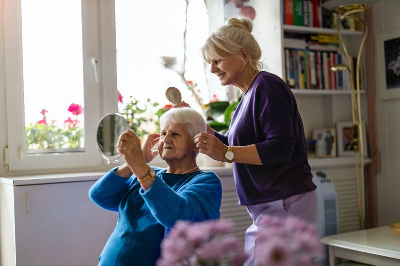 Woman combing hair of elderly mother