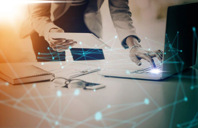 Business, laptop and digital transformation with tablet in networking with technology and data nodes at the office. Corporate manager on computer in communication, IoT and futuristic network at work