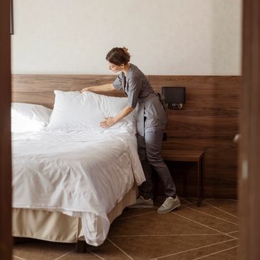 Person making a bed in a modern room.