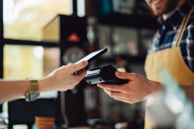 Contactless payment with smartphone in cafe.