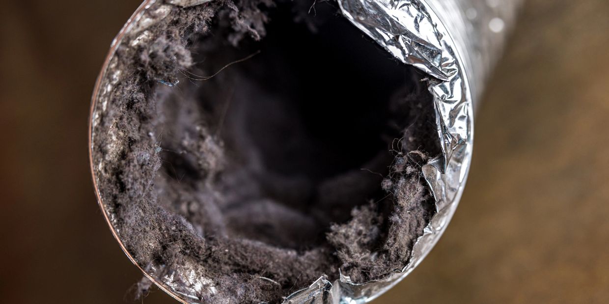 Close-up of a dust-clogged aluminum ventilation duct.