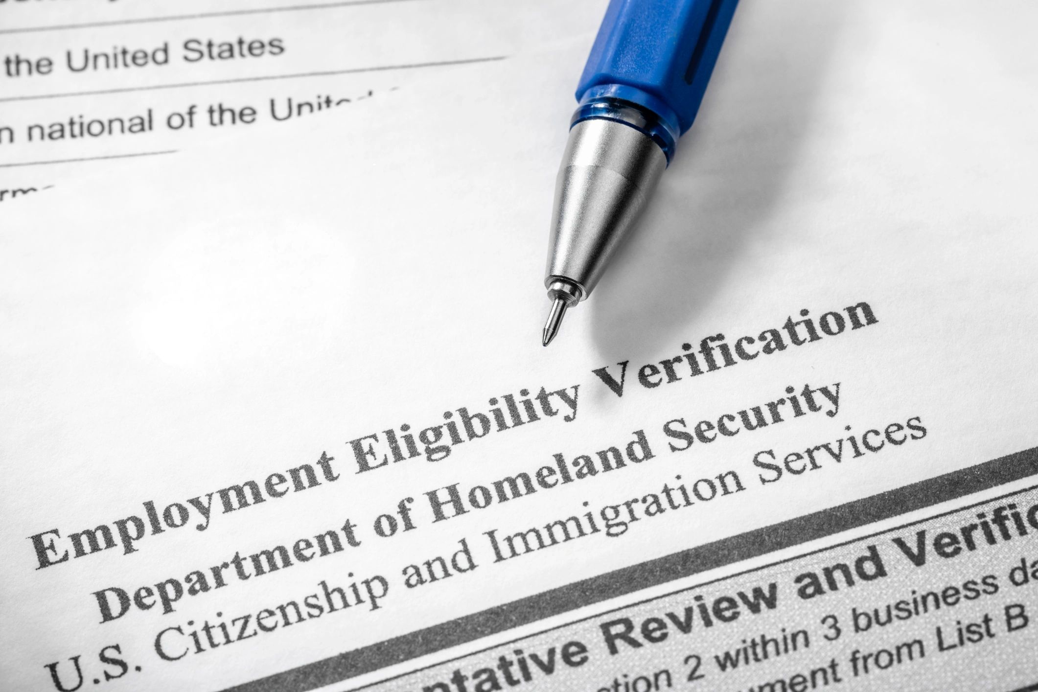 Close-up of an employment eligibility verification form with a pen.