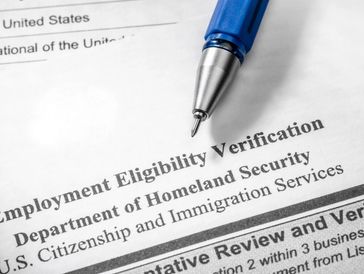Close-up of an Employment Eligibility Verification form with a pen.