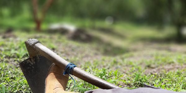 Resting in the field with a hoe and boots visible.
