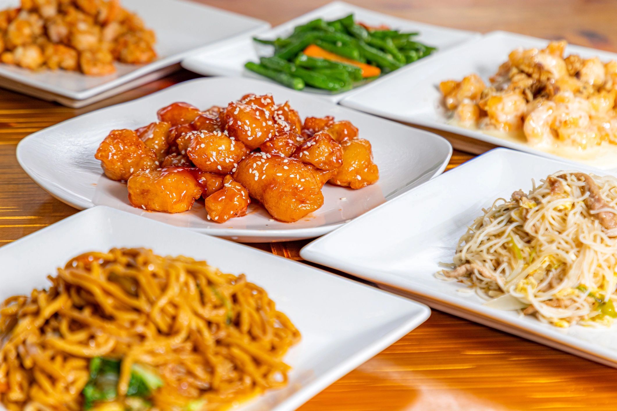 Various Asian dishes on white plates.