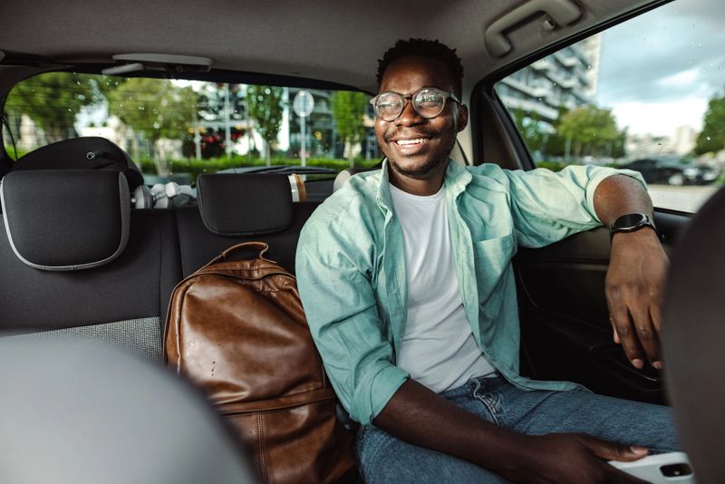 African-American male commuter sitting in taxi