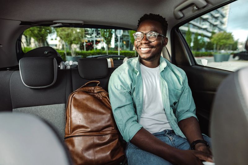African-American male commuter sitting in taxi