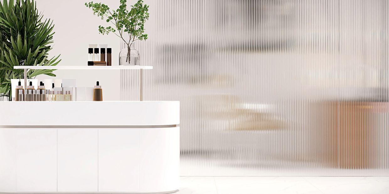 Perfume bottles on top of white table surrounded by plants