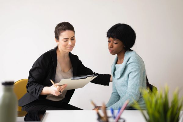 A counselor comforts a distressed woman during a session.