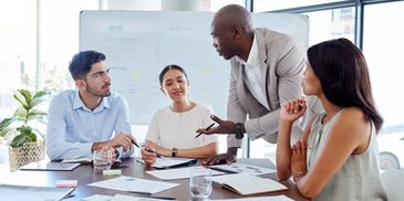 Diverse team discussing business strategies around a conference table.