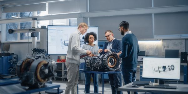 Engineers discussing an electric motor design in a high-tech workshop.