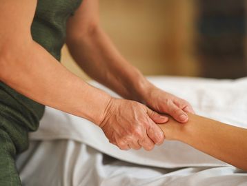 Tui na massage being carried out on the left hand of a patient.
Tui na massage in Leamington Spa.