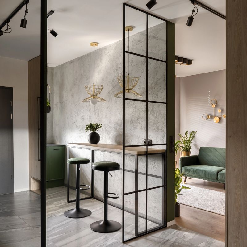 Modern apartment with industrial style reinforced glass wall and ceiling lights, concrete wall and stylish furniture