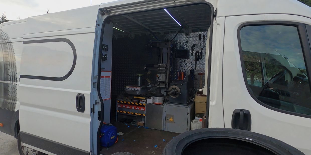Mobile technician performing on-site tire change in Toronto driveway—digital balancer in use