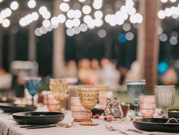 Elegant table setting with colorful glassware and bokeh lighting.