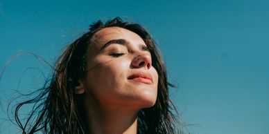 Woman enjoying sunlight with eyes closed.