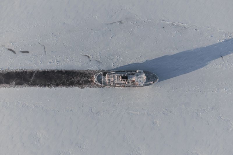 The work of the icebreaker in the ice fields. Harsh northern conditions. Laying of the navigable channel.
