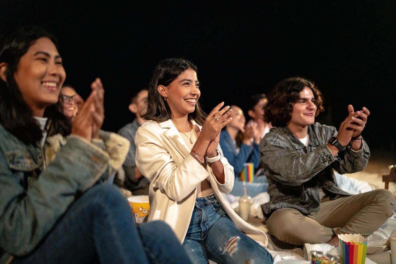 Stack of books next to pencils in a holder and a camera.