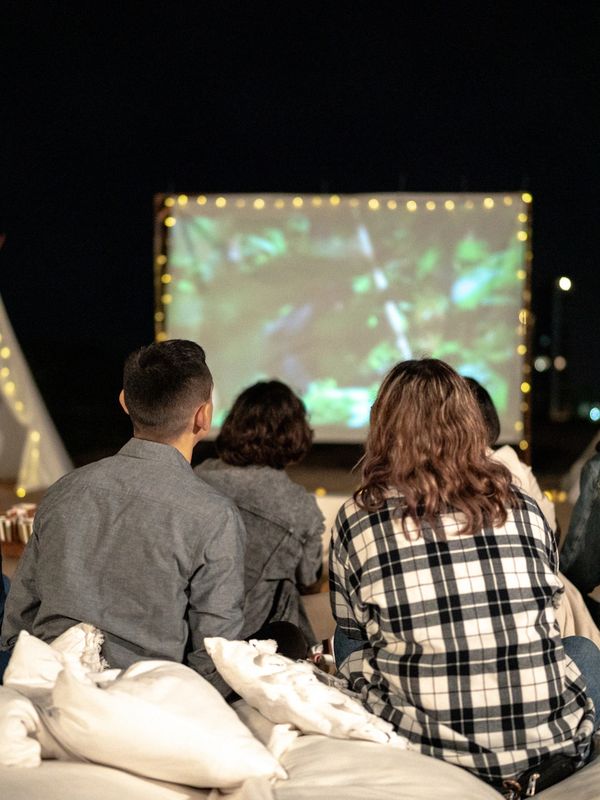 People watching an outdoor movie at night.