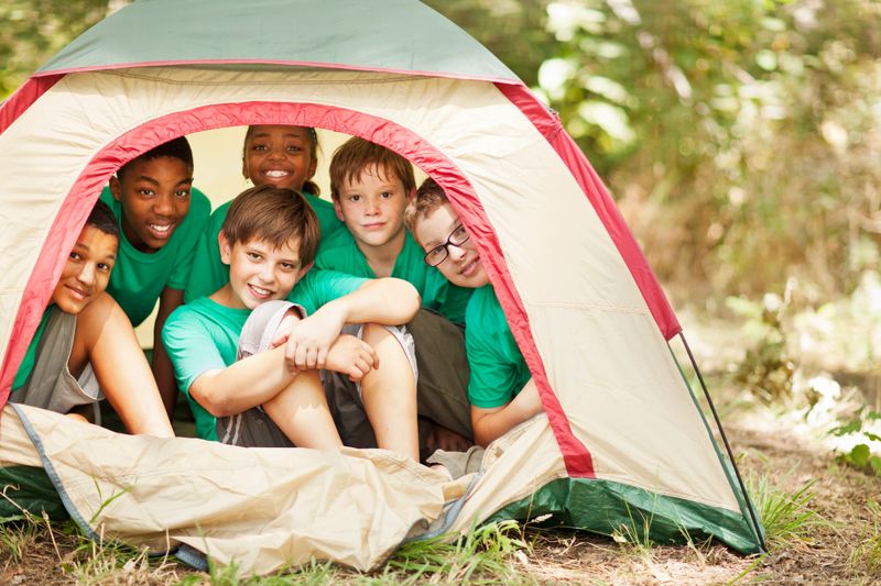 Students sitting in camp tent