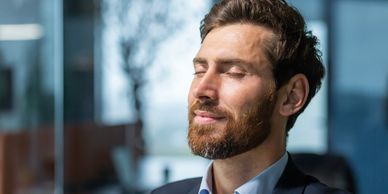 A professional man taking a meditation break at work.