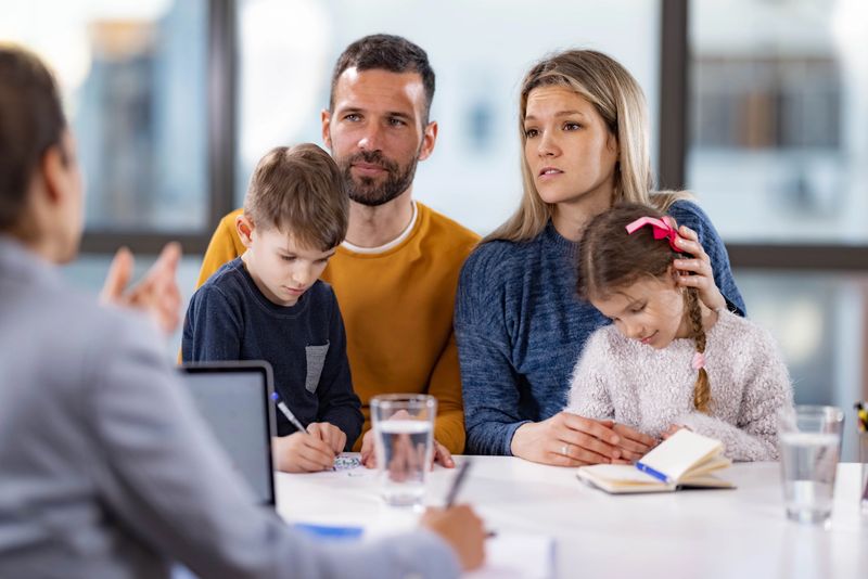 Parents and their children having a meeting at family therapist in the office.