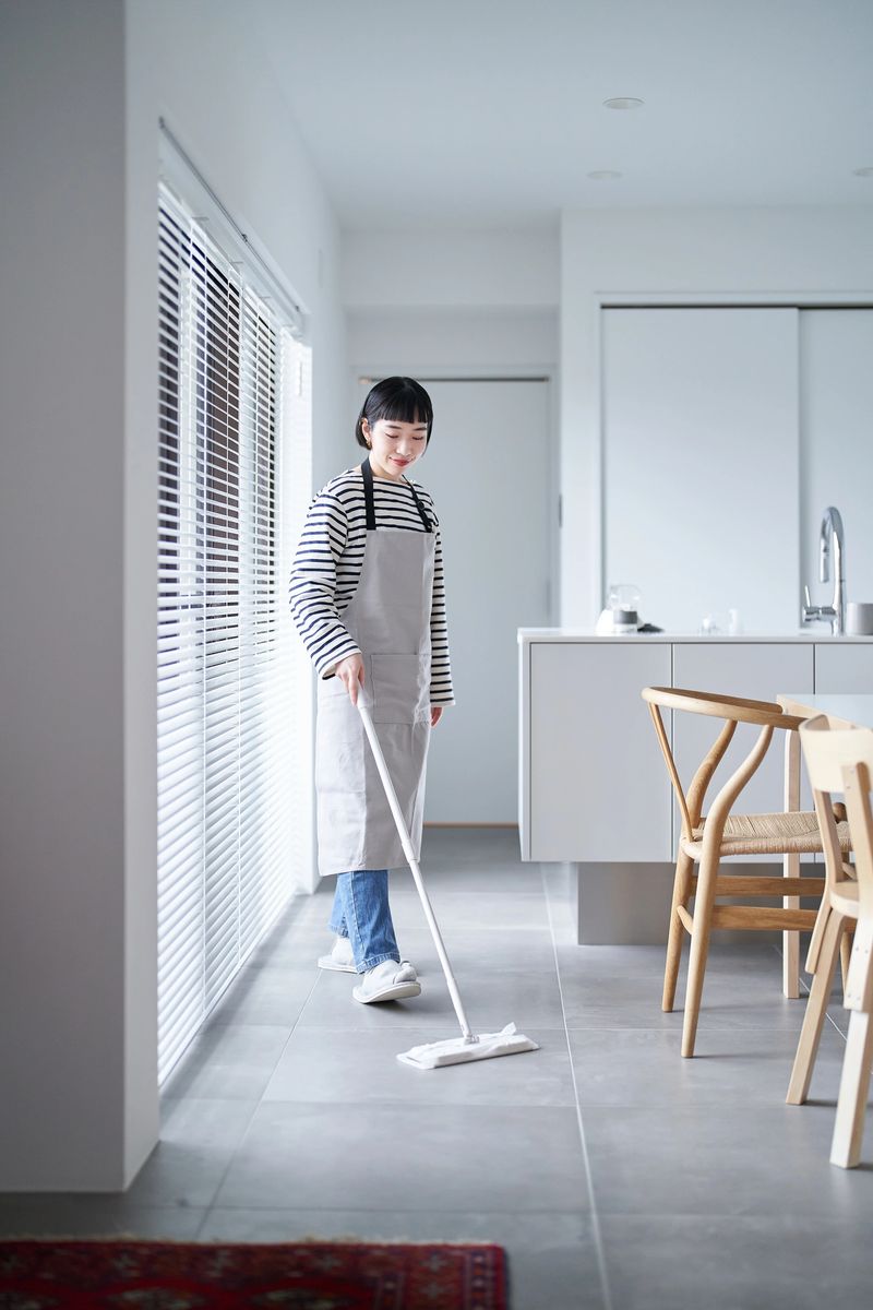 Asian young woman cleaning the floor in the room