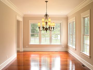 Empty room with hardwood floors and chandelier lighting.