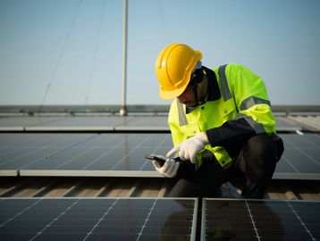 Engineer inspecting rooftop solar panels for warranty compliance.