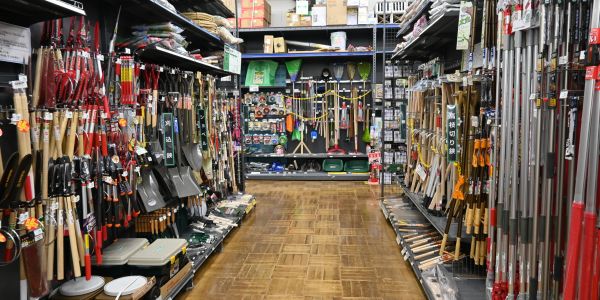 Aisle in a hardware store with gardening tools.