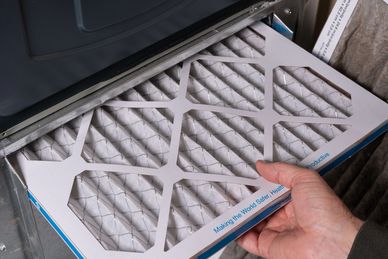 Technician replacing a home HVAC air filter