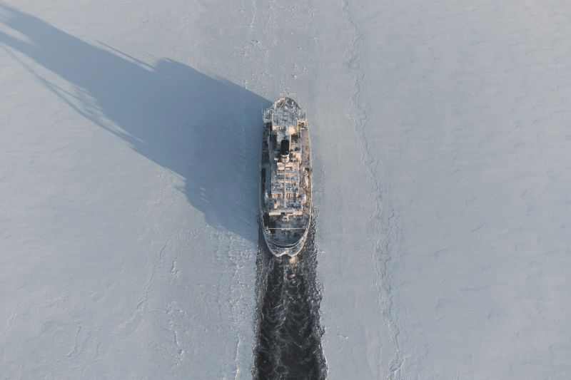 The icebreaker makes a route in the ice fields. Air view.