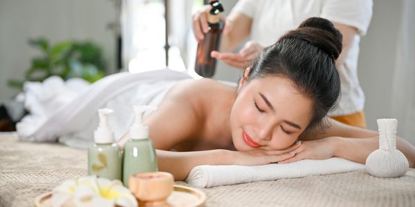 Woman enjoying a relaxing massage with aromatic oils at a spa.