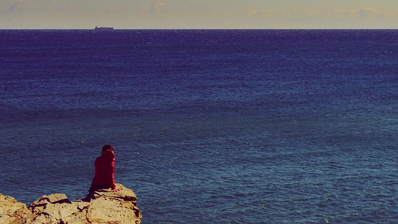 Tourist woman on spanish rocky coastline in Murcia region. Mediterranean Sea coast landscape, Calblanque Regional Park.