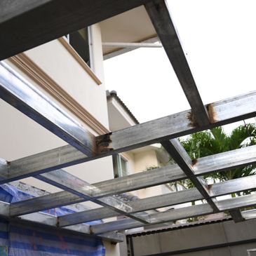 Metal frame structure under construction beside a building.