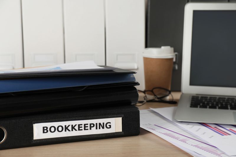 Folders, laptop and documents on desk in office. Bookkeeper's workplace