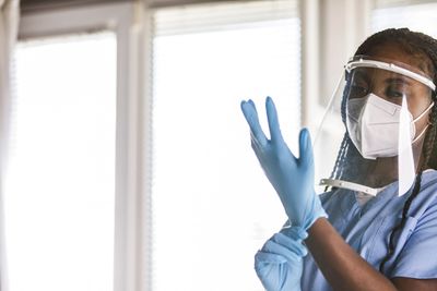 Healthcare worker putting on protective gloves.