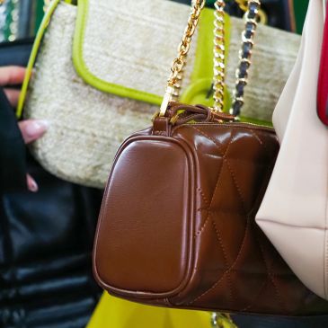 Brown leather handbag with gold chain strap.