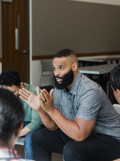 Man speaking passionately in a group discussion.