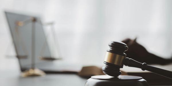 A judge's gavel and scales of justice on a desk.