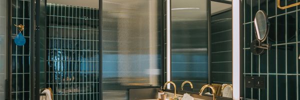 Modern bathroom vanity with dual sinks and large mirror.