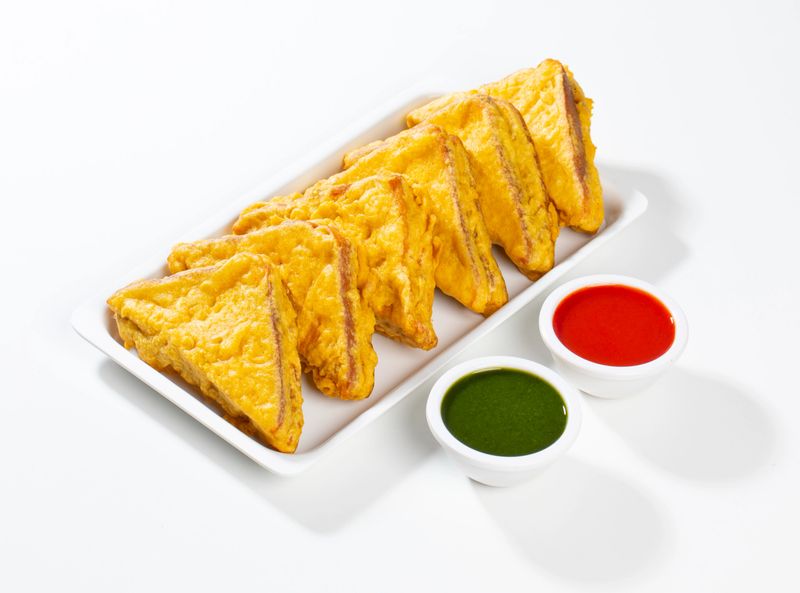 Indian Fried Snack Bread Pakora or Bread Bhaji Served with Tomato Ketchup, Green Chutney it is Made From Bread Slices, Gram Flour and Spices Among other Ingredients