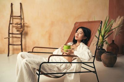 Woman relaxing on a lounge chair with a cup.