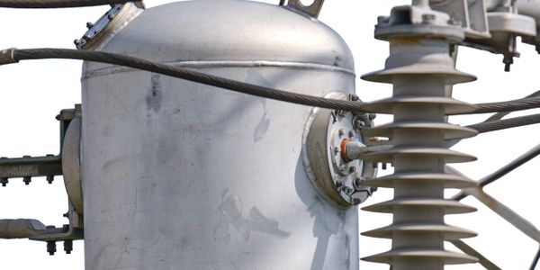 Close-up of a high-voltage electrical transformer component with connected wires.Energy Saving Device