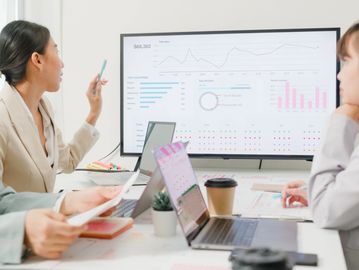 Business professional presenting financial data on a laptop during a consulting meeting