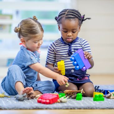 Two children playing with colorful building blocks.