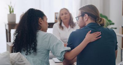 Couple comforting each other during counseling session.