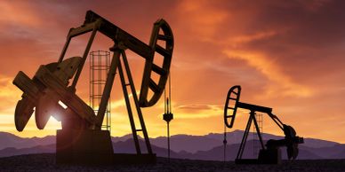 Oil pumpjacks silhouetted at sunset.