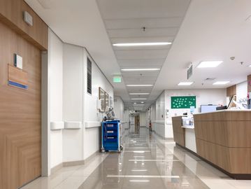 Clean and modern hospital corridor with medical equipment and nurse station.
