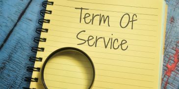 A notebook with "Term Of Service" written and a magnifying glass on it.